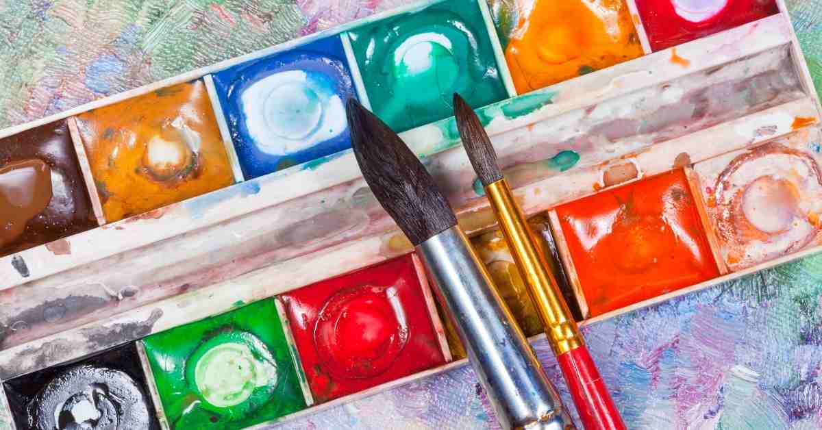 a watercolor pan set with two brushes on top of it demonstrating the best watercolor set for beginners
