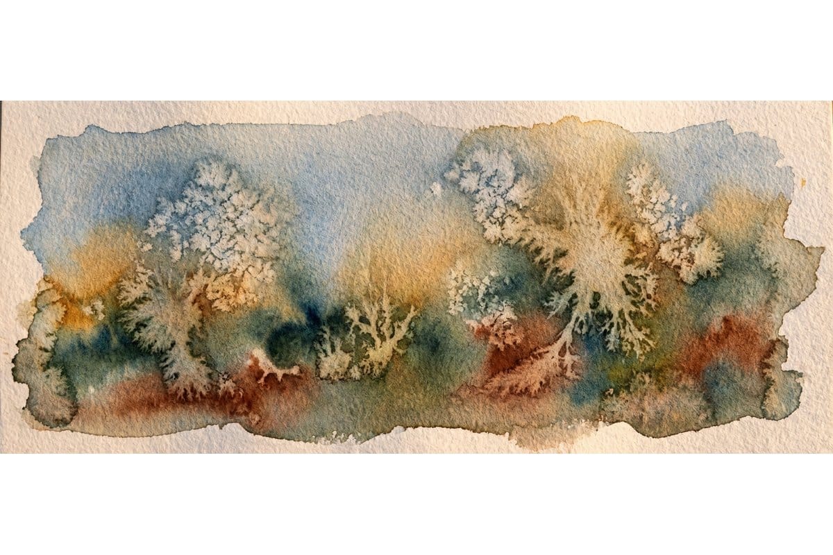 Watercolor demonstration showing preserved white areas creating light effects in a loose landscape wash