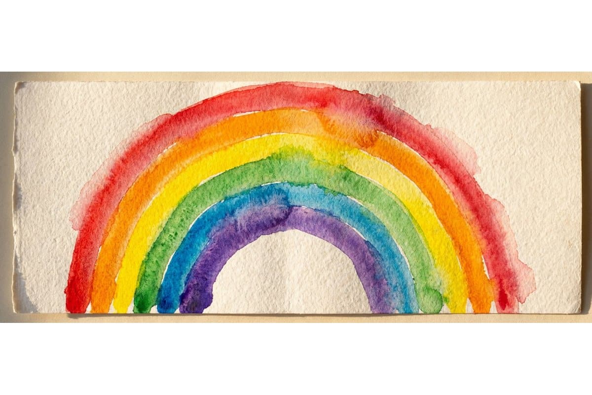 Organised kid-friendly watercolor painting station with paints brushes water cups and paper