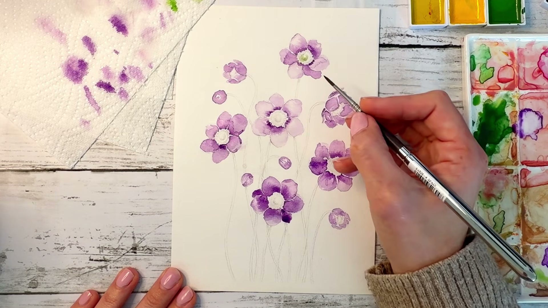 Dee's hands painting watercolour anemones, still from an Artsydee YouTube tutorial