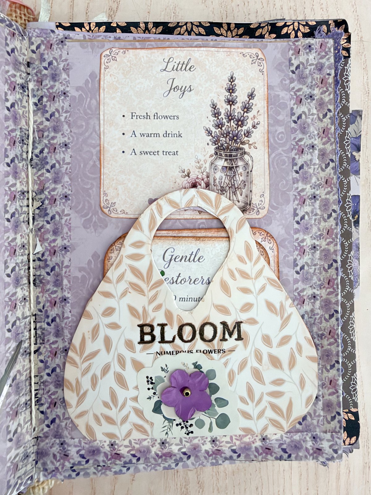 Handbag-shaped paper pocket with a purple flower on a lavender junk journal page