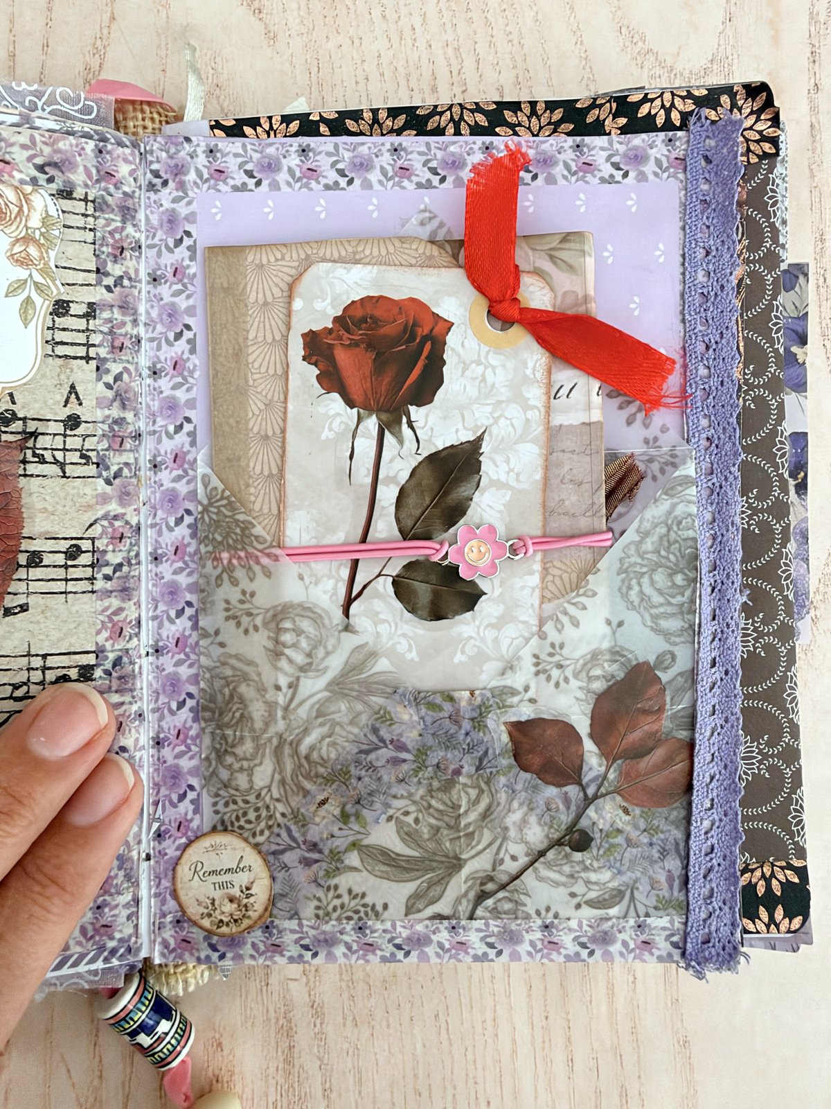 Clear packet on a lavender page holding a rose tag with a red ribbon