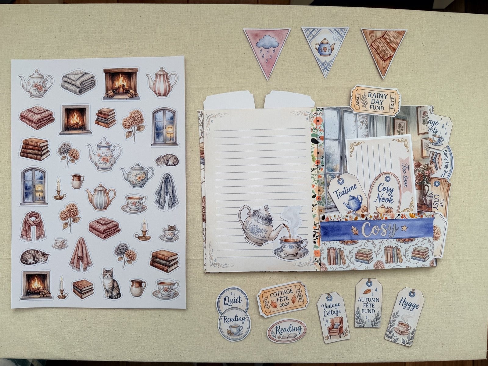 A printed Artsydee junk journal kit laid out on the table - the ephemera sheet, journal pages and cut-out tags