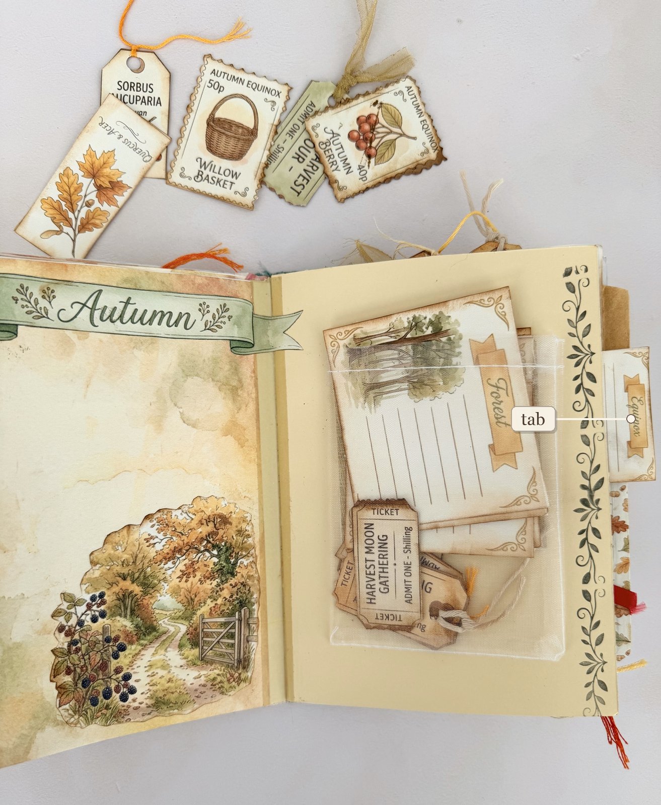 Open autumn junk journal spread with a labelled paper tab sticking out of the page edge