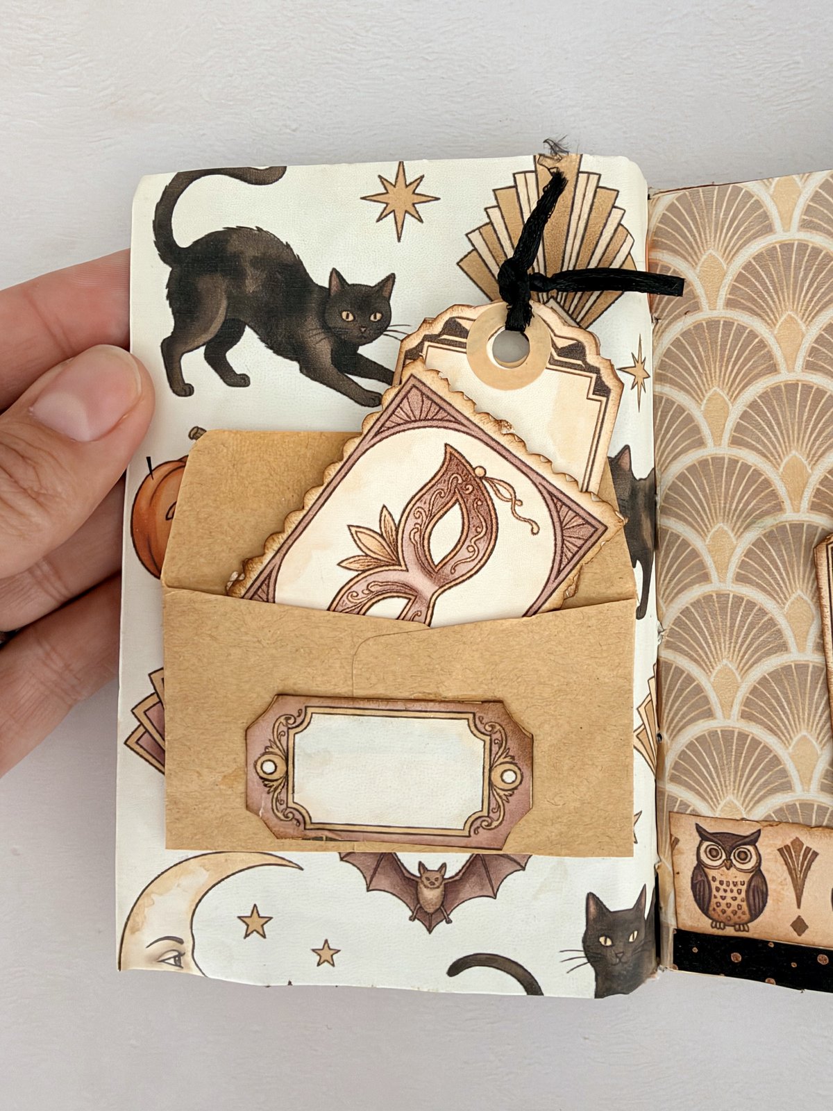 Small kraft envelope glued to a patterned page with a tag tucked inside