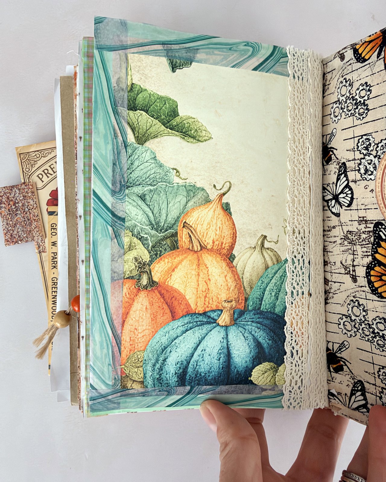 Junk journal spread with cream lace edging running down the page beside a pumpkin picture