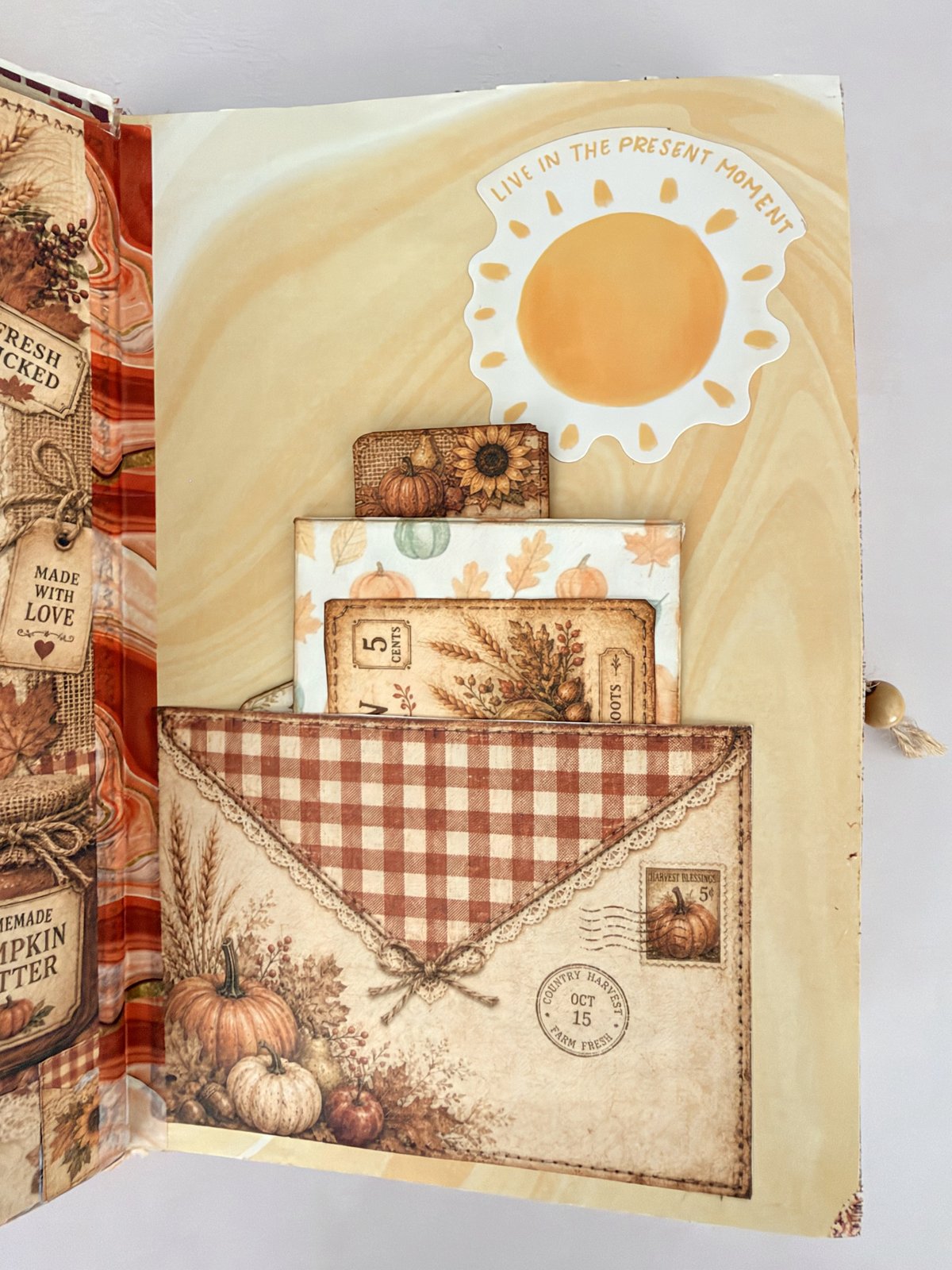 Layered envelope-style pocket with a gingham flap holding autumn journaling cards