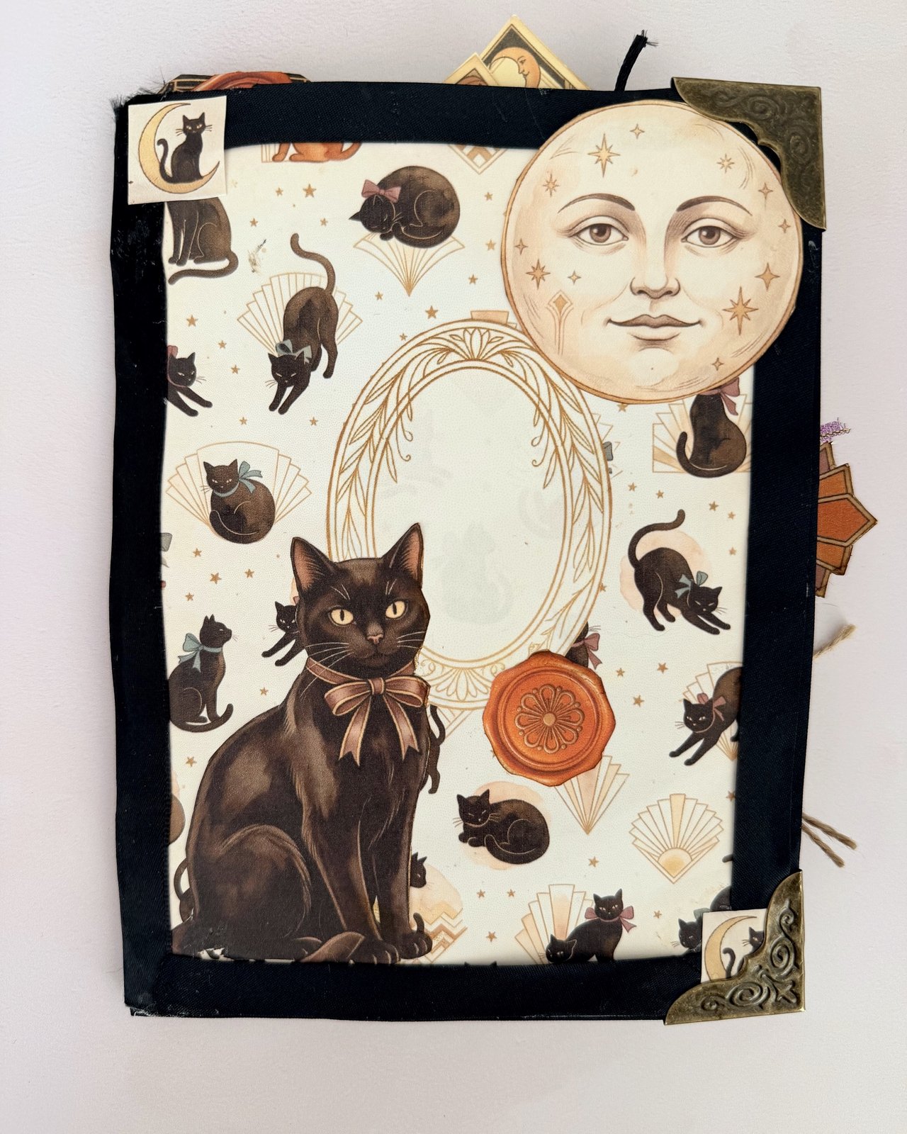 Junk journal page framed with black tape and finished with metal corners