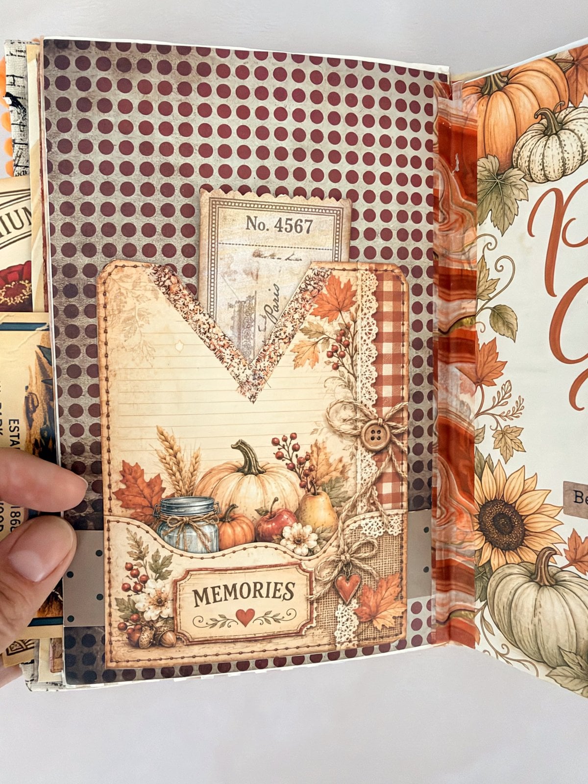 V-shaped paper pocket with a pumpkin picture holding a ticket and a numbered tag