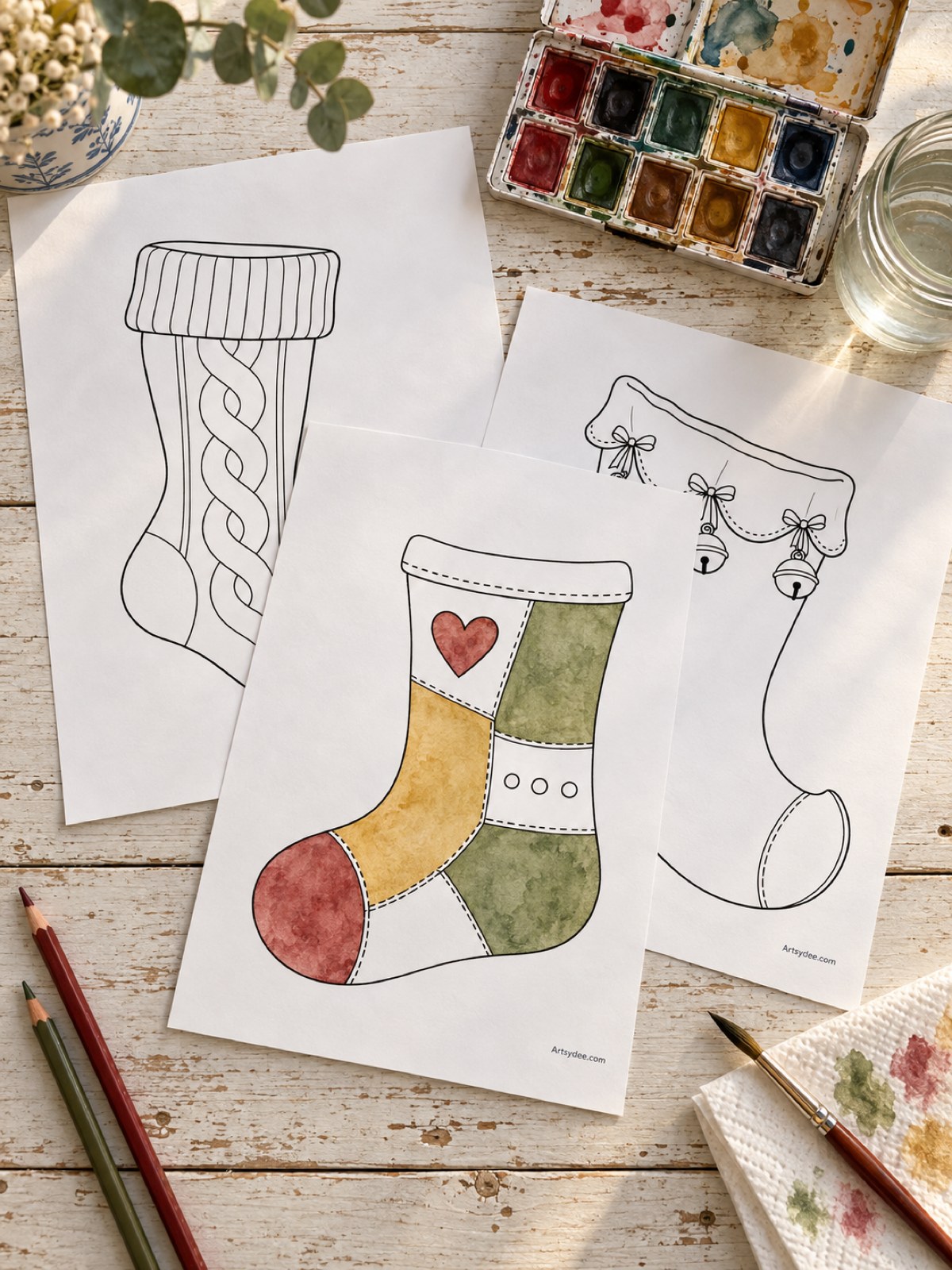 Illustrated mockup of printed stocking templates on a desk, with the patchwork stocking coloured in watercolour