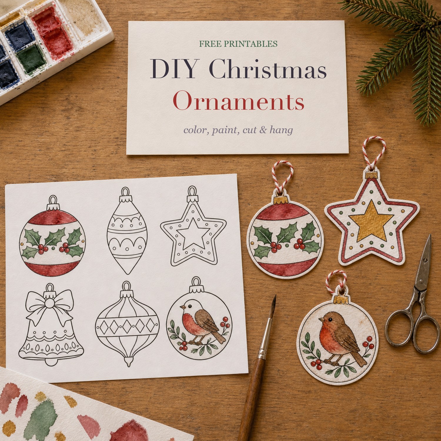A printed sheet of six Christmas ornaments, two painted, beside three cut-out watercolor ornaments on twine, paints, a brush and scissors, with a cream card reading DIY Christmas Ornaments