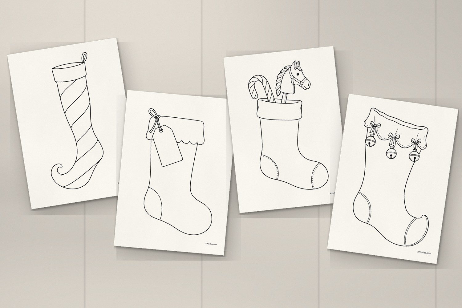 Four printed Christmas stocking templates on a desk: the slender striped stocking, the name tag stocking, the candy cane and toy stocking and the Victorian stocking with bells